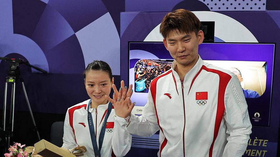 Paris 2024 Olympics - Badminton - Mixed Doubles Victory Ceremony - Porte de La Chapelle Arena, Paris, France - August 02, 2024. Si Wei Zheng of China proposes to Ya Qiong Huang of China after winning the gold. REUTERS/Ann Wang