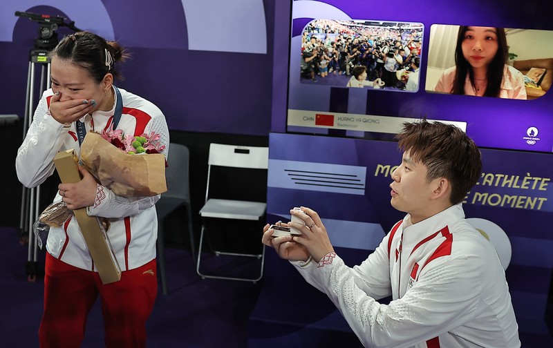 OLYMPICS-2024-BADMINTON/ Paris 2024 Olympics - Badminton - Mixed Doubles Victory Ceremony - Porte de La Chapelle Arena, Paris, France - August 02, 2024. Si Wei Zheng of China proposes to Ya Qiong Huang of China after winning the gold. REUTERS/Ann Wang