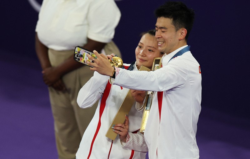 Paris 2024 Olympics - Badminton - Mixed Doubles Victory Ceremony - Porte de La Chapelle Arena, Paris, France - August 02, 2024. Si Wei Zheng of China proposes to Ya Qiong Huang of China after winning the gold. REUTERS/Ann Wang
