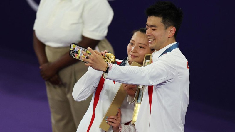 Paris 2024 Olympics - Badminton - Mixed Doubles Victory Ceremony - Porte de La Chapelle Arena, Paris, France - August 02, 2024. Si Wei Zheng of China proposes to Ya Qiong Huang of China after winning the gold. REUTERS/Ann Wang