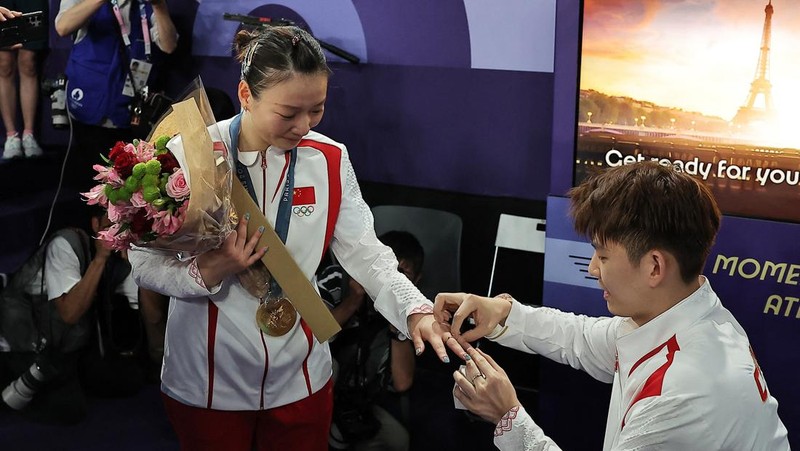 Paris 2024 Olympics - Badminton - Mixed Doubles Victory Ceremony - Porte de La Chapelle Arena, Paris, France - August 02, 2024. Si Wei Zheng of China proposes to Ya Qiong Huang of China after winning the gold. REUTERS/Ann Wang