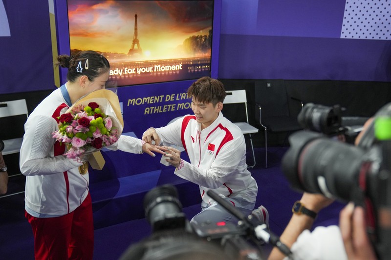 OLYMPICS-2024-BADMINTON/ Paris 2024 Olympics - Badminton - Mixed Doubles Victory Ceremony - Porte de La Chapelle Arena, Paris, France - August 02, 2024. Si Wei Zheng of China proposes to Ya Qiong Huang of China after winning the gold. REUTERS/Ann Wang