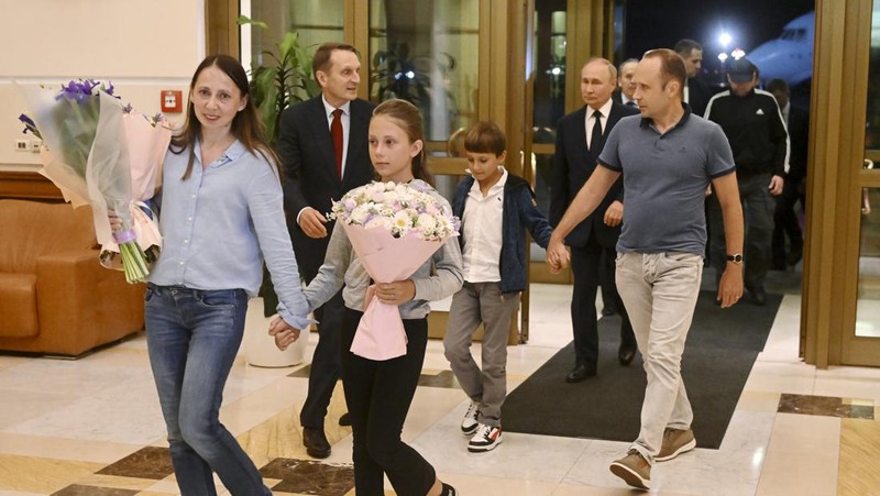 Presiden Rusia Vladimir Putin menyambut warga negara Rusia, termasuk Artyom Dultsev, Anna Dultseva dan anak-anak mereka, setelah pertukaran tahanan antara Rusia dengan negara-negara Barat, selama upacara di Bandara Internasional Vnukovo di Moskow, Rusia, 1 Agustus 2024. (Sputnik/Mikhail Voskresensky/Pool via REUTERS)