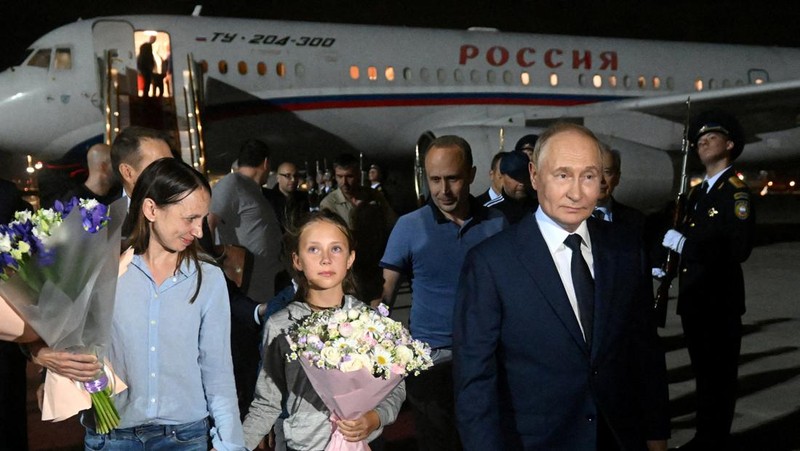 Presiden Rusia Vladimir Putin menyambut warga negara Rusia, termasuk Artyom Dultsev, Anna Dultseva dan anak-anak mereka, setelah pertukaran tahanan antara Rusia dengan negara-negara Barat, selama upacara di Bandara Internasional Vnukovo di Moskow, Rusia, 1 Agustus 2024. (Sputnik/Mikhail Voskresensky/Pool via REUTERS)