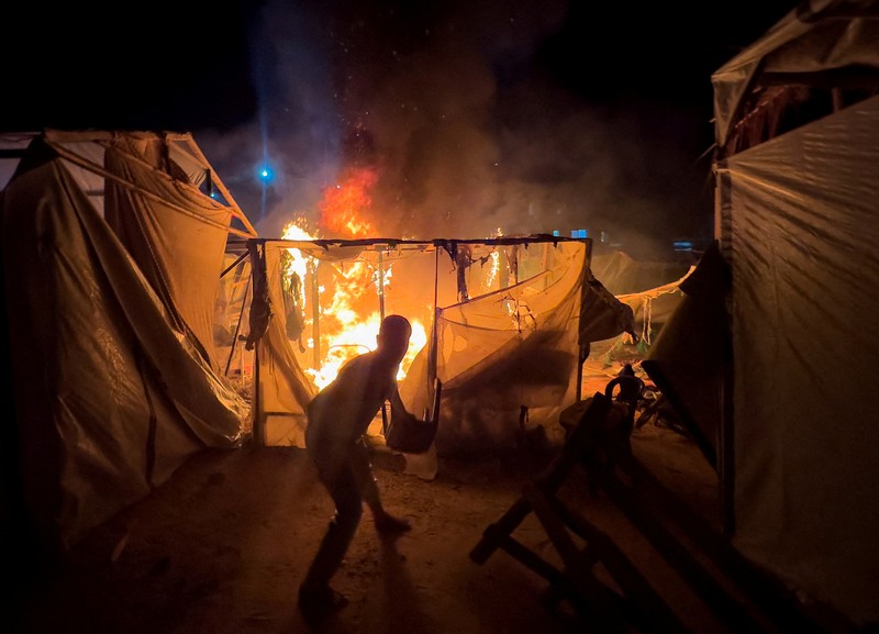 Warga Palestina bekerja memadamkan api di lokasi serangan Israel terhadap kamp tenda bagi para pengungsi, di tengah konflik Israel-Hamas, di Deir Al-Balah di Jalur Gaza tengah, 4 Agustus 2024. Warga Palestina bekerja memadamkan api di lokasi serangan Israel terhadap kamp tenda bagi para pengungsi, di tengah konflik Israel-Hamas, di Deir Al-Balah di Jalur Gaza tengah, 4 Agustus 2024. (REUTERS/Abdullah Al-Attar)