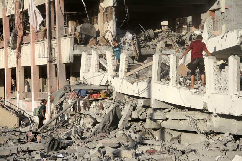 Warga Palestina memeriksa lokasi serangan Israel terhadap sekolah yang melindungi orang-orang terlantar, di tengah konflik Israel-Hamas, di Kota Gaza, 3 Agustus 2024. Warga Palestina memeriksa lokasi serangan Israel terhadap sekolah yang melindungi orang-orang terlantar, di tengah konflik Israel-Hamas, di Kota Gaza, 3 Agustus 2024. (REUTERS/Mahmoud Issa)