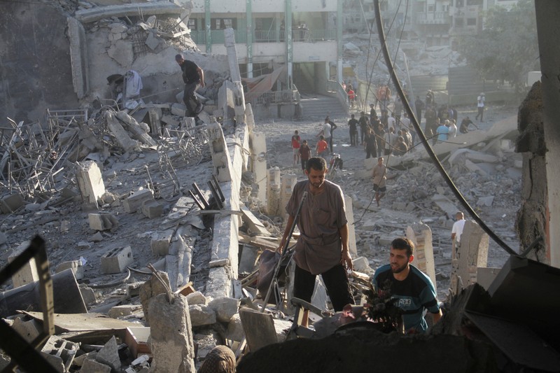 Warga Palestina memeriksa lokasi serangan Israel terhadap sekolah yang melindungi orang-orang terlantar, di tengah konflik Israel-Hamas, di Kota Gaza, 3 Agustus 2024. Warga Palestina memeriksa lokasi serangan Israel terhadap sekolah yang melindungi orang-orang terlantar, di tengah konflik Israel-Hamas, di Kota Gaza, 3 Agustus 2024. (REUTERS/Mahmoud Issa)