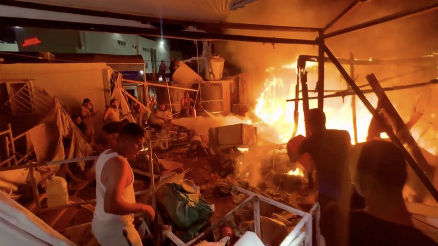Warga Palestina bekerja memadamkan api di lokasi serangan Israel terhadap kamp tenda bagi para pengungsi, di tengah konflik Israel-Hamas, di Deir Al-Balah di Jalur Gaza tengah, 4 Agustus 2024. (REUTERS/Abdullah Al-Attar)
