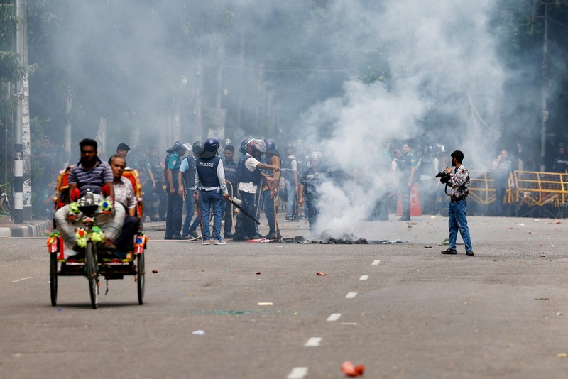 Pria berlari melewati pusat perbelanjaan yang dibakar oleh pengunjuk rasa selama unjuk rasa menentang Perdana Menteri Sheikh Hasina dan pemerintahannya yang menuntut keadilan bagi para korban yang tewas dalam bentrokan mematikan baru-baru ini di seluruh negeri, di Dhaka, Bangladesh, Minggu, 4 Agustus 2024. Pria berlari melewati pusat perbelanjaan yang dibakar oleh pengunjuk rasa selama unjuk rasa menentang Perdana Menteri Sheikh Hasina dan pemerintahannya yang menuntut keadilan bagi para korban yang tewas dalam bentrokan mematikan baru-baru ini di seluruh negeri, di Dhaka, Bangladesh, Minggu, 4 Agustus 2024. (AP Photo/Rajib Dhar)