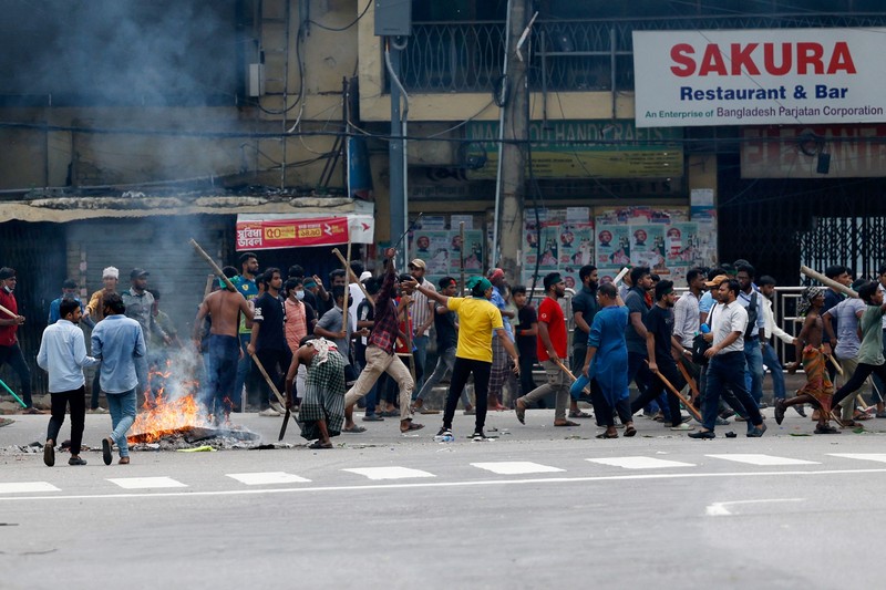Pria berlari melewati pusat perbelanjaan yang dibakar oleh pengunjuk rasa selama unjuk rasa menentang Perdana Menteri Sheikh Hasina dan pemerintahannya yang menuntut keadilan bagi para korban yang tewas dalam bentrokan mematikan baru-baru ini di seluruh negeri, di Dhaka, Bangladesh, Minggu, 4 Agustus 2024. Pria berlari melewati pusat perbelanjaan yang dibakar oleh pengunjuk rasa selama unjuk rasa menentang Perdana Menteri Sheikh Hasina dan pemerintahannya yang menuntut keadilan bagi para korban yang tewas dalam bentrokan mematikan baru-baru ini di seluruh negeri, di Dhaka, Bangladesh, Minggu, 4 Agustus 2024. (AP Photo/Rajib Dhar)