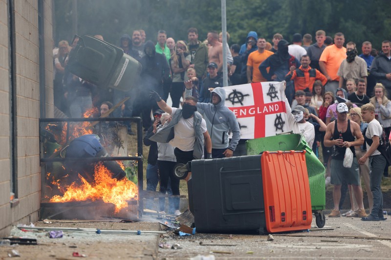 Petugas polisi berdiri di hadapan para demonstran selama protes anti-imigrasi, di Rotherham, Inggris, 4 Agustus 2024. Petugas polisi berdiri di hadapan para demonstran selama protes anti-imigrasi, di Rotherham, Inggris, 4 Agustus 2024. (REUTERS/Hollie Adams)