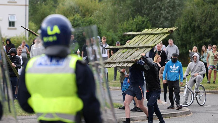 Petugas polisi berdiri di hadapan para demonstran selama protes anti-imigrasi, di Rotherham, Inggris, 4 Agustus 2024. (REUTERS/Hollie Adams)