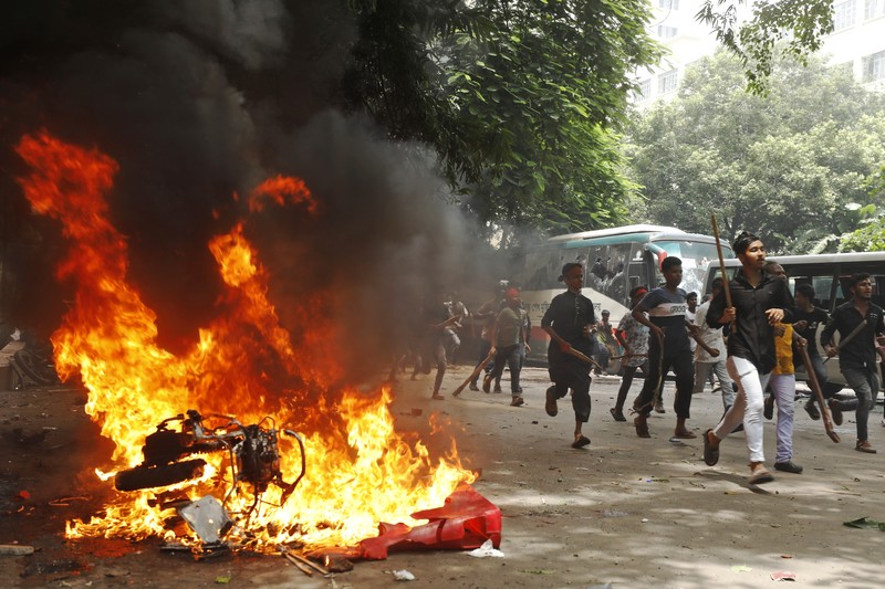 Pria berlari melewati pusat perbelanjaan yang dibakar oleh pengunjuk rasa selama unjuk rasa menentang Perdana Menteri Sheikh Hasina dan pemerintahannya yang menuntut keadilan bagi para korban yang tewas dalam bentrokan mematikan baru-baru ini di seluruh negeri, di Dhaka, Bangladesh, Minggu, 4 Agustus 2024. Pria berlari melewati pusat perbelanjaan yang dibakar oleh pengunjuk rasa selama unjuk rasa menentang Perdana Menteri Sheikh Hasina dan pemerintahannya yang menuntut keadilan bagi para korban yang tewas dalam bentrokan mematikan baru-baru ini di seluruh negeri, di Dhaka, Bangladesh, Minggu, 4 Agustus 2024. (AP Photo/Rajib Dhar)