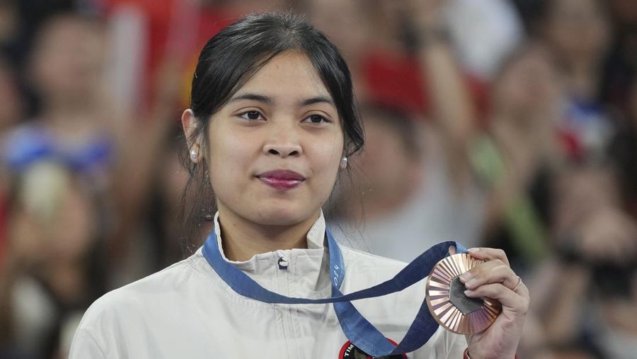 Pebulu tangkis tunggal putri Indonesia Gregoria Mariska Tunjung merayakan kemenangannya di podium setelah meraih medali perunggu di cabang bulu tangkis tunggal putri Olimpiade Musim Panas 2024, Senin, 5 Agustus 2024, di Paris, Prancis. (AP/Kin Cheung)
