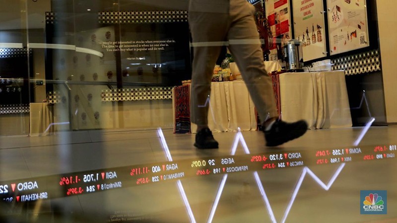 Pengunjung melintas di depan layar pergerakan saham di Bursa Efek Indonesia, Jakarta, Senin (5/8/2024). Koreksi Indeks Harga Saham Gabungan (IHSG) terpantau sudah mencapai 4% pada perdagangan sesi II. (վ/Muhammad Sabki)