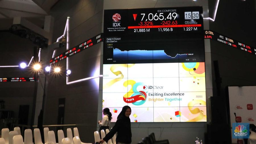 Pengunjung melintas di depan layar pergerakan saham di Bursa Efek Indonesia, Jakarta, Senin (5/8/2024). Koreksi Indeks Harga Saham Gabungan (IHSG) terpantau sudah mencapai 4% pada perdagangan sesi II. (CNBC Indonesia/Muhammad Sabki)