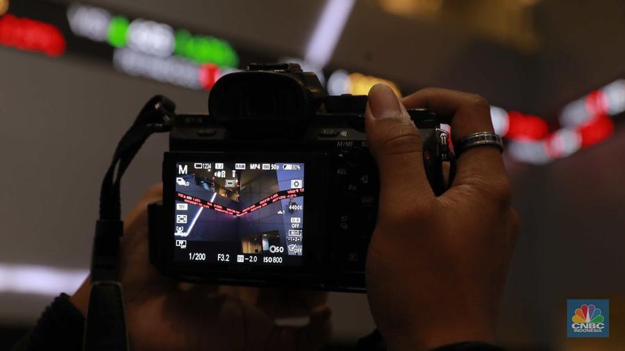 Pengunjung melintas di depan layar pergerakan saham di Bursa Efek Indonesia, Jakarta, Senin, (5/8/2024). Koreksi Indeks Harga Saham Gabungan (IHSG) terpantau sudah mencapai 4% pada perdagangan sesi II. (CNBC Indonesia/Muhammad Sabki)