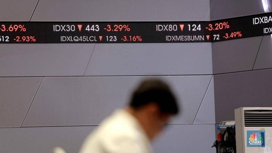 Pengunjung melintas di depan layar pergerakan saham di Bursa Efek Indonesia, Jakarta, Senin, (5/8/2024). Koreksi Indeks Harga Saham Gabungan (IHSG) terpantau sudah mencapai 4% pada perdagangan sesi II. (CNBC Indonesia/Muhammad Sabki)