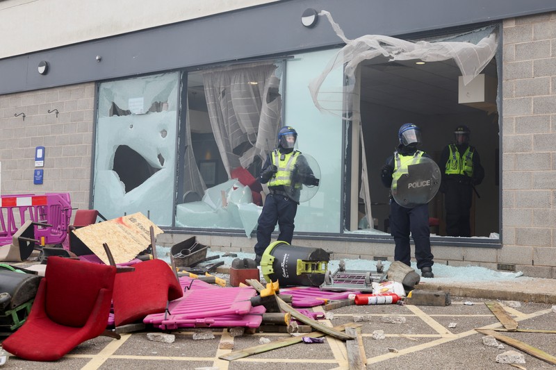 Petugas polisi berdiri di hadapan para demonstran selama protes anti-imigrasi, di Rotherham, Inggris, 4 Agustus 2024. Petugas polisi berdiri di hadapan para demonstran selama protes anti-imigrasi, di Rotherham, Inggris, 4 Agustus 2024. (REUTERS/Hollie Adams)
