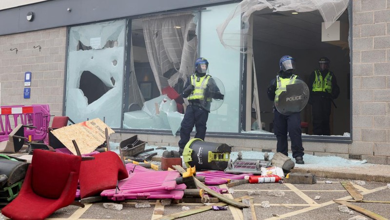 Petugas polisi berdiri di hadapan para demonstran selama protes anti-imigrasi, di Rotherham, Inggris, 4 Agustus 2024. (REUTERS/Hollie Adams)