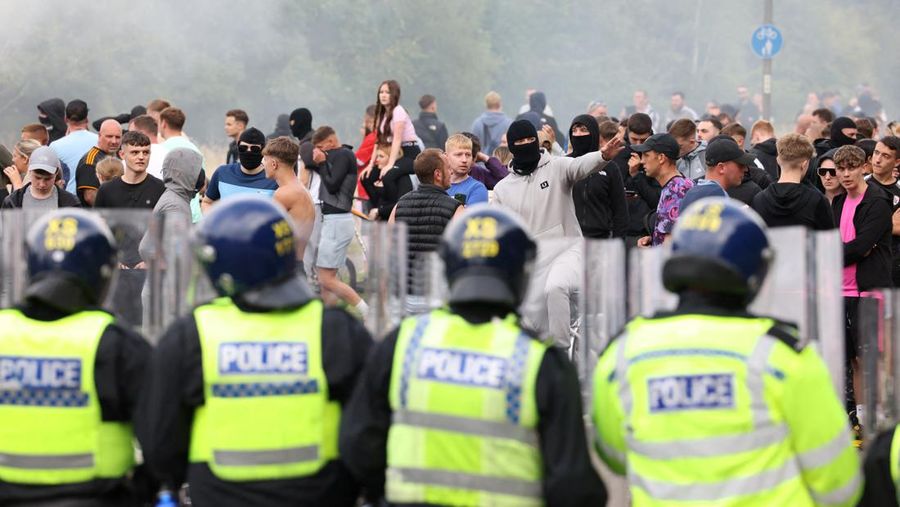 Petugas polisi berdiri di hadapan para demonstran selama protes anti-imigrasi, di Rotherham, Inggris, 4 Agustus 2024. (REUTERS/Hollie Adams)