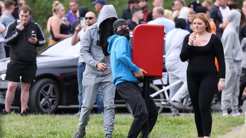 Petugas polisi berdiri di hadapan para demonstran selama protes anti-imigrasi, di Rotherham, Inggris, 4 Agustus 2024. (REUTERS/Hollie Adams)