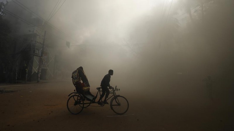 Pria berlari melewati pusat perbelanjaan yang dibakar oleh pengunjuk rasa selama unjuk rasa menentang Perdana Menteri Sheikh Hasina dan pemerintahannya yang menuntut keadilan bagi para korban yang tewas dalam bentrokan mematikan baru-baru ini di seluruh negeri, di Dhaka, Bangladesh, Minggu, 4 Agustus 2024. (AP Photo/Rajib Dhar)