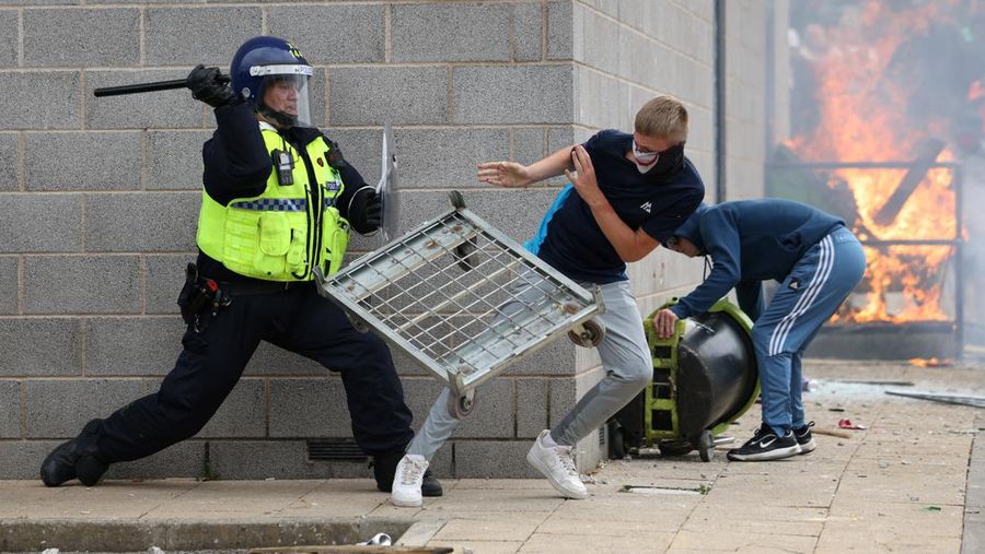 Seorang petugas polisi beroperasi saat seorang demonstran menjauh selama protes anti-imigrasi, di Rotherham, Inggris, 4 Agustus 2024. (REUTERS/Hollie Adams)