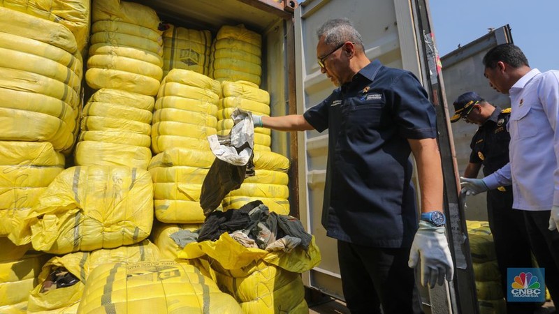 Petugas Bea Cukai berjaga disamping pakain bekas (balpres) di Tempat Penimbunan Pabean (TPP) Bea dan Cukai, Cikarang, Kabupaten Bekasi, Jawa Barat, Selasa (6/8/2024). (CNBC Indonesia/Faisal Rahman)