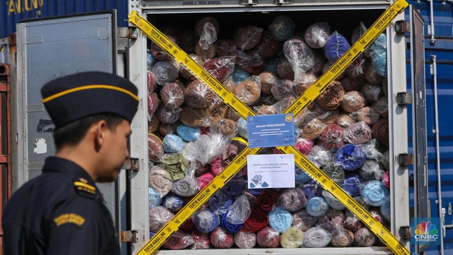 Petugas Bea Cukai berjaga disamping pakain bekas (balpres) di Tempat Penimbunan Pabean (TPP) Bea dan Cukai, Cikarang, Kabupaten Bekasi, Jawa Barat, Selasa (6/8/2024). (վ/Faisal Rahman)