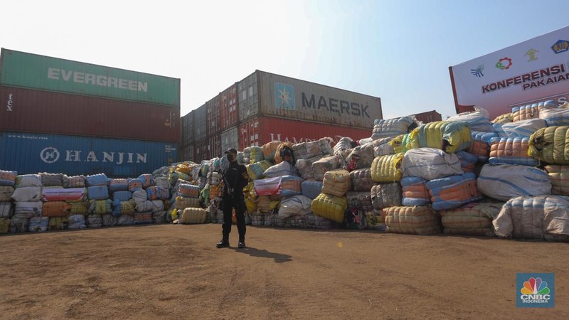 Petugas Bea Cukai berjaga disamping pakain bekas (balpres) di Tempat Penimbunan Pabean (TPP) Bea dan Cukai, Cikarang, Kabupaten Bekasi, Jawa Barat, Selasa (6/8/2024). (CNBC Indonesia/Faisal Rahman)