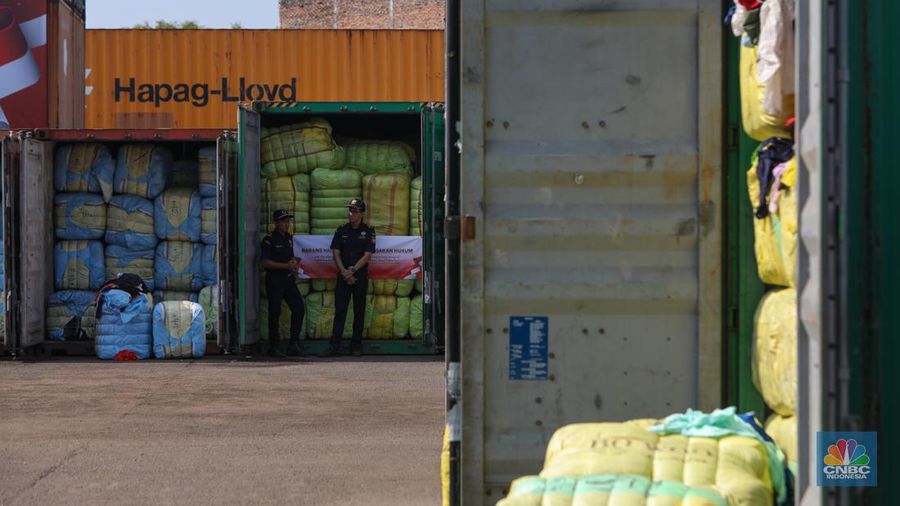 Petugas Bea Cukai berjaga disamping pakain bekas (balpres) di Tempat Penimbunan Pabean (TPP) Bea dan Cukai, Cikarang, Kabupaten Bekasi, Jawa Barat, Selasa (6/8/2024). (CNBC Indonesia/Faisal Rahman)