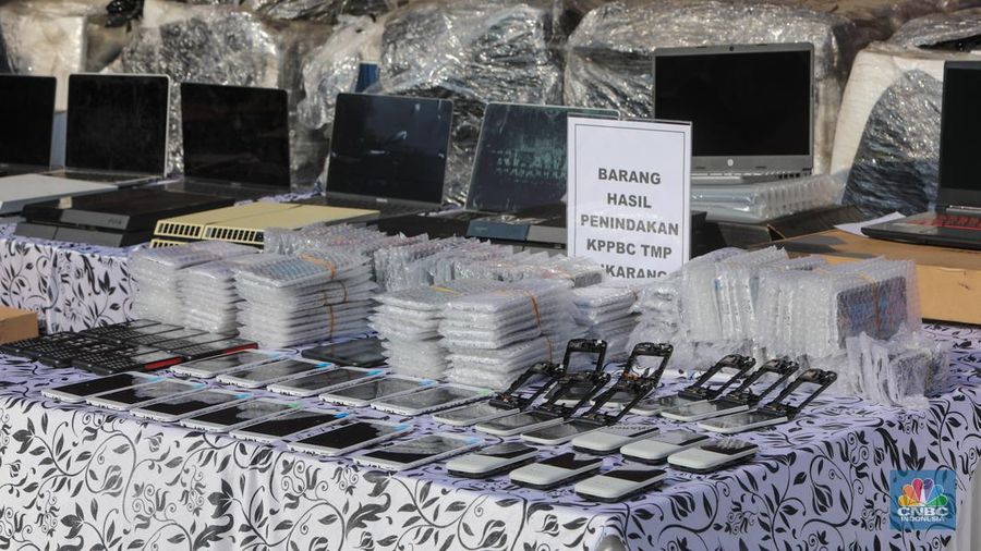 Petugas Bea Cukai berjaga disamping pakain bekas (balpres) di Tempat Penimbunan Pabean (TPP) Bea dan Cukai, Cikarang, Kabupaten Bekasi, Jawa Barat, Selasa (6/8/2024). (CNBC Indonesia/Faisal Rahman)