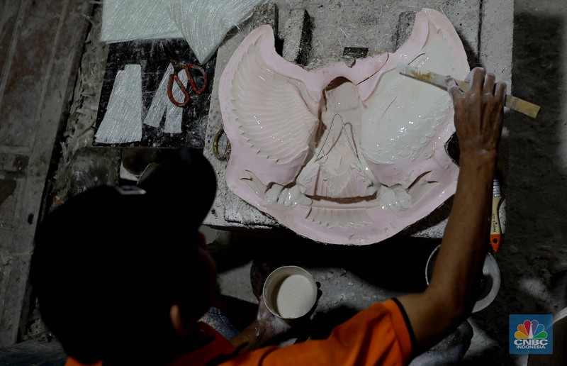 Pekerja menyelesaikan pembuatan patung fiber Garuda Pancasila di bengkel kerja Garuda Fiber, Makasar, Jakarta Timur, Rabu (7/8/2024). Menjelang HUT ke-79 Republik Indonesia, penjualan patung fiber Garuda Pancasila mengalami kenaikan permintaan sebesar 50 persen. (CNBC Indonesia/Muhammad Sabki)