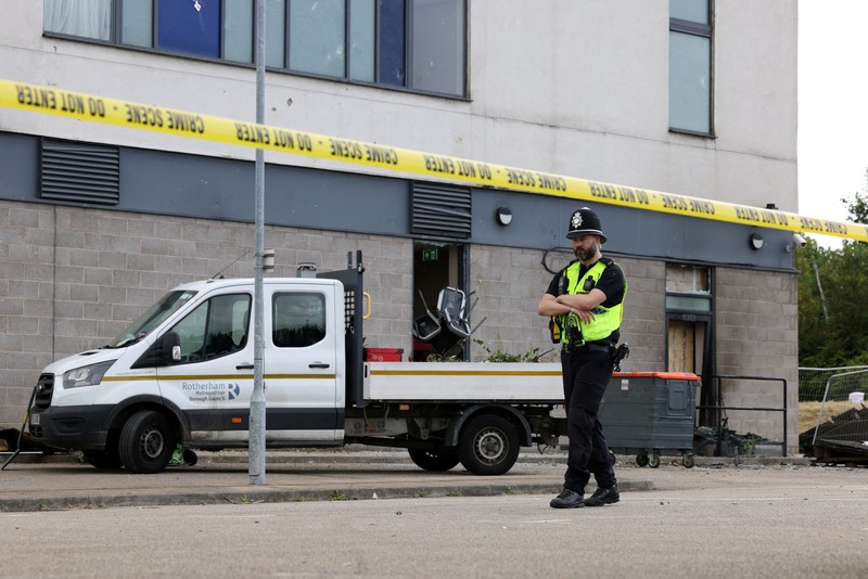 Seorang petugas polisi berjalan di luar hotel Holiday Inn Express setelah perusuh menyerang gedung tersebut di Rotherham, Inggris, 5 Agustus 2024. Pemerintah mengatakan gedung tersebut digunakan oleh pencari suaka. Seorang petugas polisi berjalan di luar hotel Holiday Inn Express setelah perusuh menyerang gedung tersebut di Rotherham, Inggris, 5 Agustus 2024. Pemerintah mengatakan gedung tersebut digunakan oleh pencari suaka. (REUTERS/Hollie Adams)