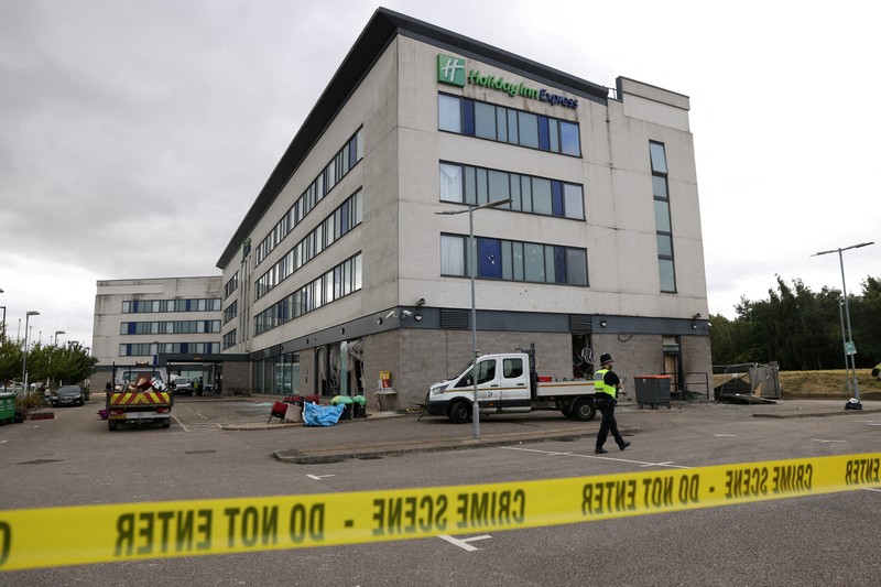 Seorang petugas polisi berjalan di luar hotel Holiday Inn Express setelah perusuh menyerang gedung tersebut di Rotherham, Inggris, 5 Agustus 2024. Pemerintah mengatakan gedung tersebut digunakan oleh pencari suaka. Seorang petugas polisi berjalan di luar hotel Holiday Inn Express setelah perusuh menyerang gedung tersebut di Rotherham, Inggris, 5 Agustus 2024. Pemerintah mengatakan gedung tersebut digunakan oleh pencari suaka. (REUTERS/Hollie Adams)