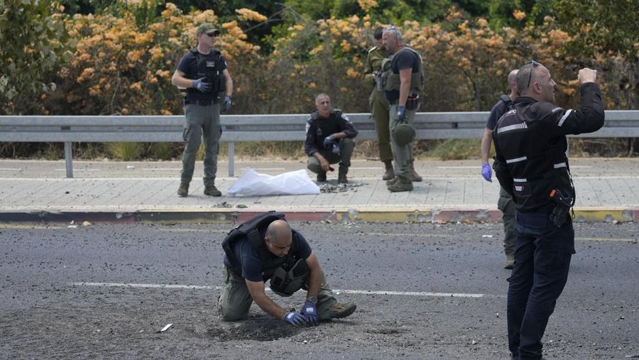 Seorang polisi dan tentara Israel memeriksa lokasi jatuhnya proyektil, setelah kelompok bersenjata Lebanon, Hizbullah, mengatakan telah meluncurkan segerombolan pesawat nirawak serang terhadap target militer di Israel utara, di Nahariya. (via REUTERS/VIDEO OBTAINED BY REUTERS)