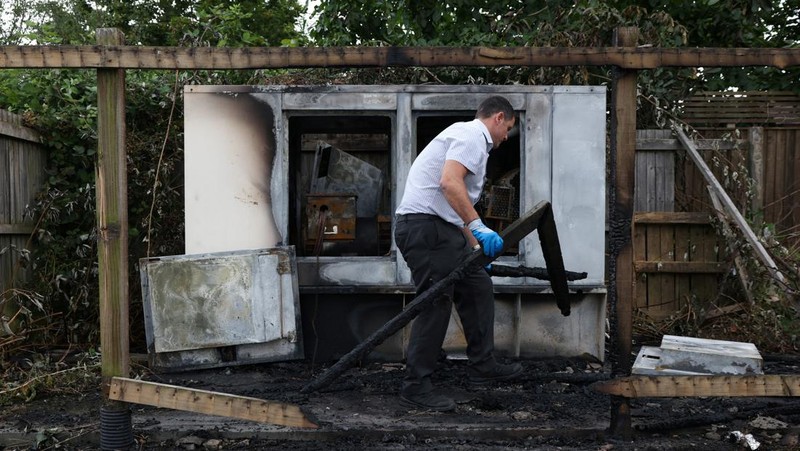 Seorang petugas polisi berjalan di luar hotel Holiday Inn Express setelah perusuh menyerang gedung tersebut di Rotherham, Inggris, 5 Agustus 2024. Pemerintah mengatakan gedung tersebut digunakan oleh pencari suaka. (REUTERS/Hollie Adams)