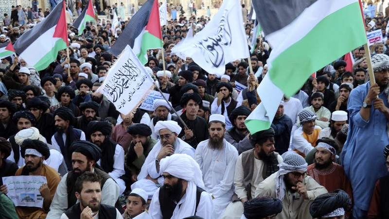 Demonstran mengibarkan bendera Palestina dan Taliban selama protes terhadap pembunuhan pemimpin Hamas Ismail Haniyeh, di masjid Jami di Herat, pada 7 Agustus 2024. (AP Photo/Omid Haqjoo)