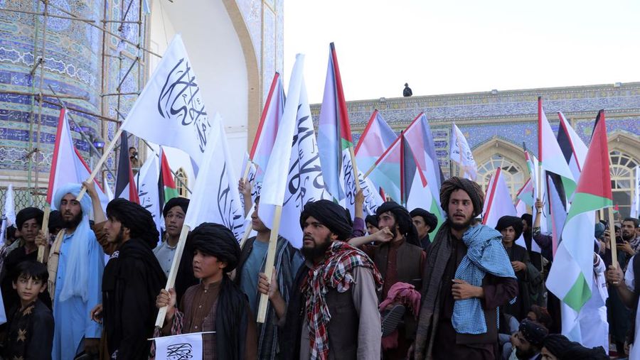 Demonstran mengibarkan bendera Palestina dan Taliban selama protes terhadap pembunuhan pemimpin Hamas Ismail Haniyeh, di masjid Jami di Herat, pada 7 Agustus 2024. (AP Photo/Omid Haqjoo)