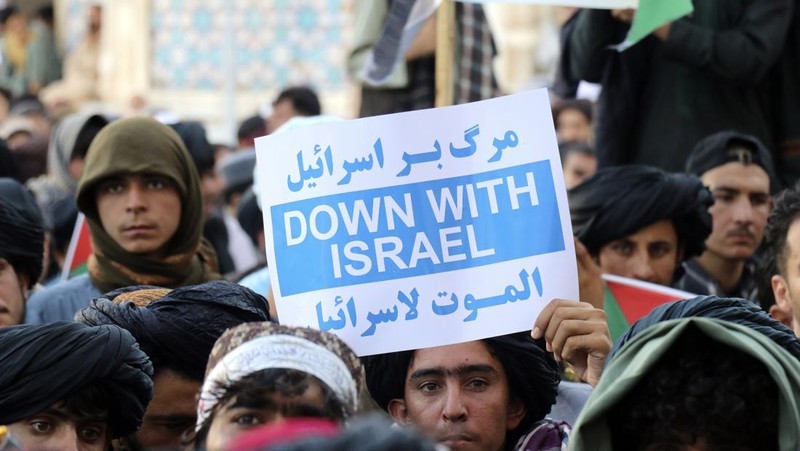 Demonstran mengibarkan bendera Palestina dan Taliban selama protes terhadap pembunuhan pemimpin Hamas Ismail Haniyeh, di masjid Jami di Herat, pada 7 Agustus 2024. (AP Photo/Omid Haqjoo)