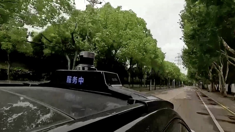 Mobil tanpa pengemudi oleh Apollo Go, layanan robotaxi milik Baidu, memberi jalan kepada mobil lain yang berputar balik di persimpangan di Wuhan, provinsi Hubei, Cina, 19 Juli 2024. (REUTERS/Ethan Wang)