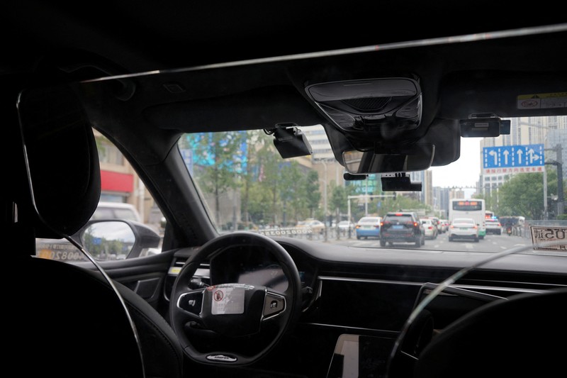 Mobil tanpa pengemudi oleh Apollo Go, layanan robotaxi milik Baidu, memberi jalan kepada mobil lain yang berputar balik di persimpangan di Wuhan, provinsi Hubei, Cina, 19 Juli 2024. (REUTERS/Ethan Wang)