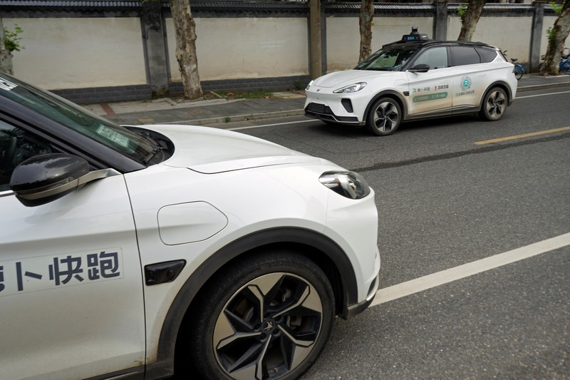 Mobil tanpa pengemudi oleh Apollo Go, layanan robotaxi milik Baidu, memberi jalan kepada mobil lain yang berputar balik di persimpangan di Wuhan, provinsi Hubei, Cina, 19 Juli 2024. (REUTERS/Ethan Wang)