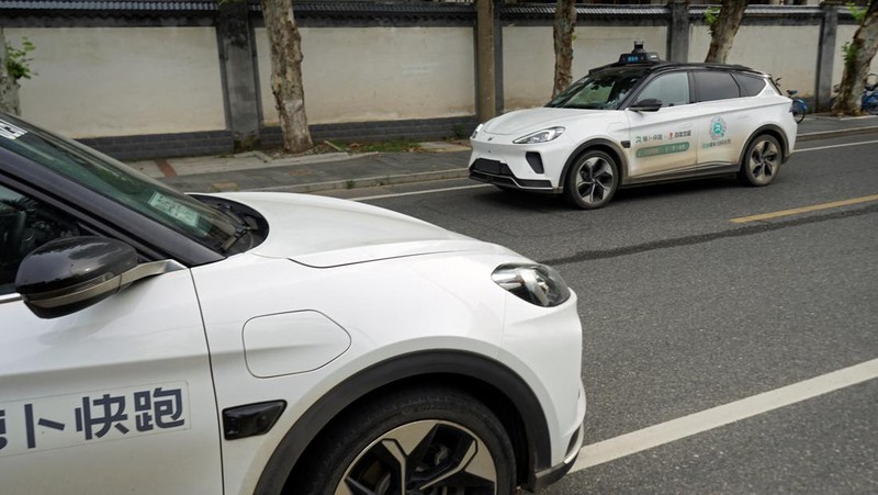 Mobil tanpa pengemudi oleh Apollo Go, layanan robotaxi milik Baidu, memberi jalan kepada mobil lain yang berputar balik di persimpangan di Wuhan, provinsi Hubei, Cina, 19 Juli 2024. (REUTERS/Ethan Wang)