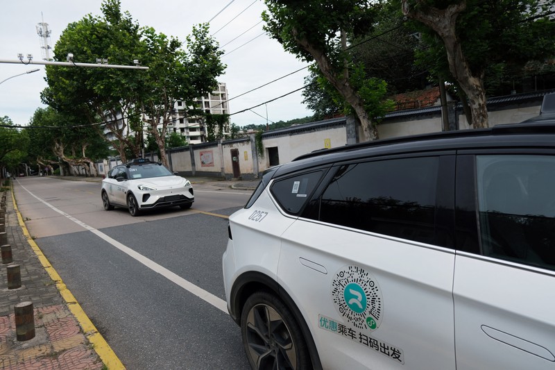 Mobil tanpa pengemudi oleh Apollo Go, layanan robotaxi milik Baidu, memberi jalan kepada mobil lain yang berputar balik di persimpangan di Wuhan, provinsi Hubei, Cina, 19 Juli 2024. (REUTERS/Ethan Wang)