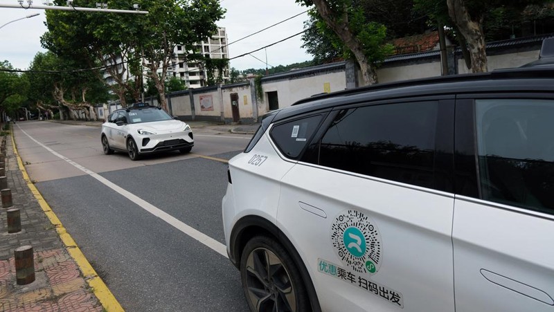 Mobil tanpa pengemudi oleh Apollo Go, layanan robotaxi milik Baidu, memberi jalan kepada mobil lain yang berputar balik di persimpangan di Wuhan, provinsi Hubei, Cina, 19 Juli 2024. (REUTERS/Ethan Wang)