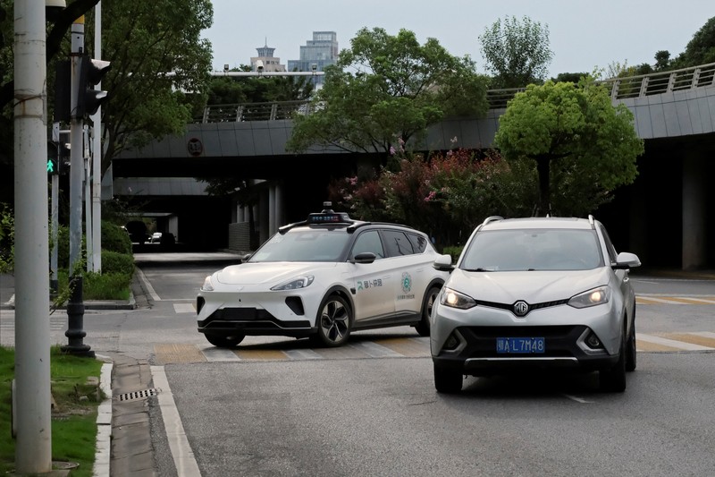 Mobil tanpa pengemudi oleh Apollo Go, layanan robotaxi milik Baidu, memberi jalan kepada mobil lain yang berputar balik di persimpangan di Wuhan, provinsi Hubei, Cina, 19 Juli 2024. Mobil tanpa pengemudi oleh Apollo Go, layanan robotaxi milik Baidu, memberi jalan kepada mobil lain yang berputar balik di persimpangan di Wuhan, provinsi Hubei, Cina, 19 Juli 2024. (REUTERS/Ethan Wang)