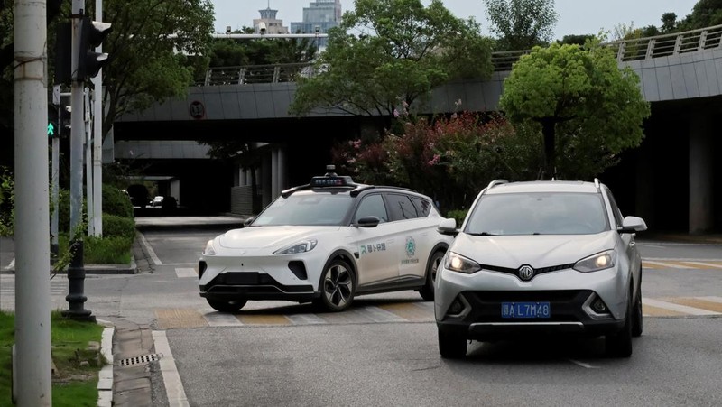 Mobil tanpa pengemudi oleh Apollo Go, layanan robotaxi milik Baidu, memberi jalan kepada mobil lain yang berputar balik di persimpangan di Wuhan, provinsi Hubei, Cina, 19 Juli 2024. (REUTERS/Ethan Wang)