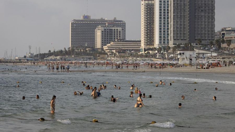 Orang-orang berenang di pantai di Tel Aviv, pada 7 Agustus 2024, di tengah ketegangan regional selama perang yang sedang berlangsung antara Israel dan gerakan Hamas Palestina di Jalur Gaza. (AFP/OREN ZIV)